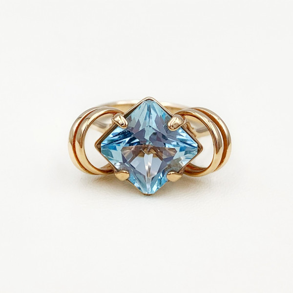 Золотое кольцо в красном цвете с голубым топазом