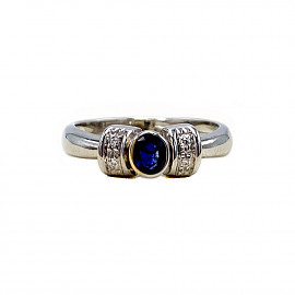 Золотое кольцо белого цвета с синим корундом и белыми бриллиантами