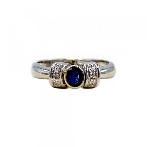 Золотое кольцо белого цвета с синим корундом и белыми бриллиантами